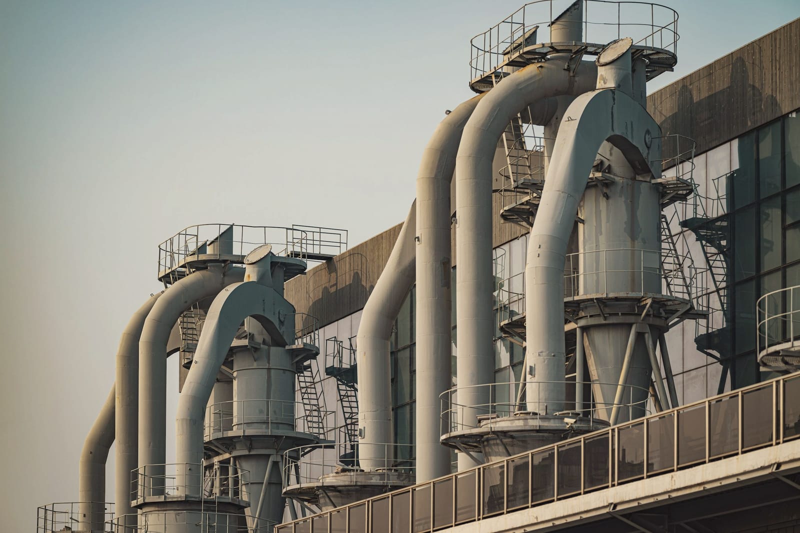 Rows of pipes on an industrial building against the sky